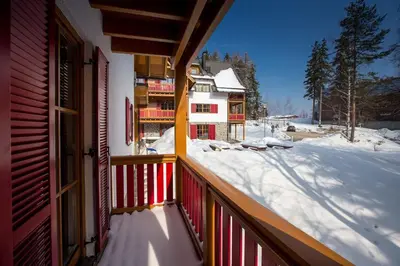 a balcony of a house with snow on the ground at Bolfenk lodge apartment in Pohorje