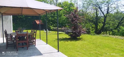 a table and chairs under an umbrella in a yard at Villa FRIDA in Rogaška Slatina