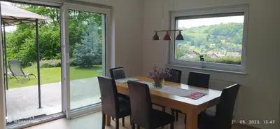 a dining room with a table and chairs and a large window at Villa FRIDA in Rogaška Slatina