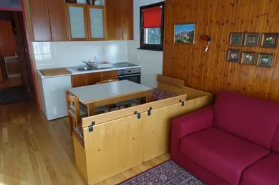 a living room with a couch and a kitchen at Retro apartments Kaninska vas in Bovec