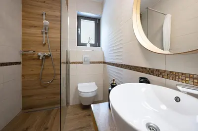 a bathroom with a sink and a toilet and a mirror at Hiša Vally Art in Bled