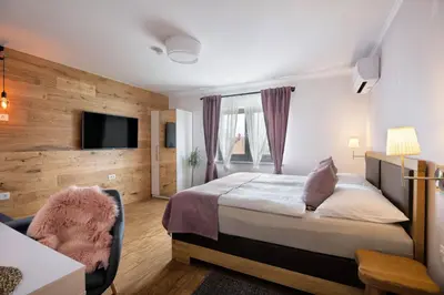 a hotel room with a bed and a chair at Hiša Vally Art in Bled