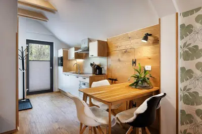 a kitchen and dining room with a wooden table and chairs at Hiša Vally Art in Bled