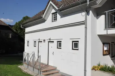a white house with white doors and a staircase at Vas Lipa 7 -30 in Podčetrtek