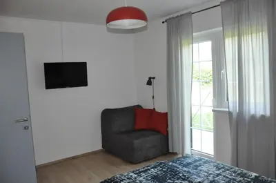 a bedroom with a bed and a chair and a window at Vas Lipa 7 -30 in Podčetrtek
