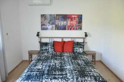 a bedroom with a bed with red pillows at Vas Lipa 7 -30 in Podčetrtek