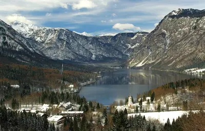 a lake in the middle of a snowy mountain at Apartmaji Alpski cvet - Hiša Gorenc in Bohinj