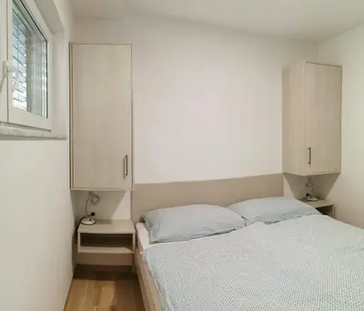 a bedroom with a bed and white cabinets at Brand new house Luna in Bled