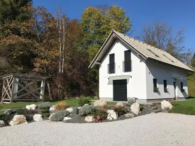 a small white building with a gate and a garden at Brand new house Luna in Bled
