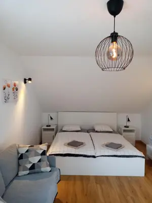 a bedroom with a bed and a couch at Apartma Vojvoda in Bohinj