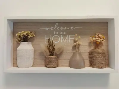 a shelf with three vases and a sign that says welcome to our home at Apartma Vojvoda in Bohinj