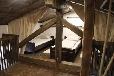 two beds in a room with wooden floors and ceilings at Apartma Skednj in Kobarid