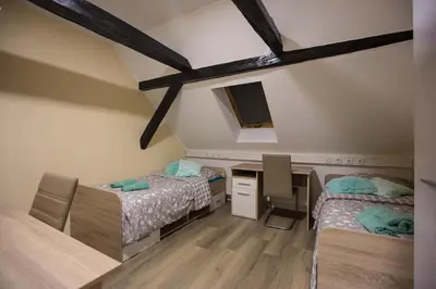 a attic room with two beds and a desk and a desk at MINIDORM ROOMS IN HEART OF CITY CENTER in Maribor