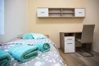 a bedroom with a bed with blue towels on it at MINIDORM ROOMS IN HEART OF CITY CENTER in Maribor