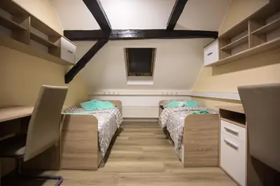 two twin beds in a room with a desk at MINIDORM ROOMS IN HEART OF CITY CENTER in Maribor