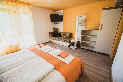 a bedroom with a large bed and a couch at Apartma Rombon Brdo with Free Onsite Parking in Bovec