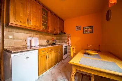 a kitchen with wooden cabinets and a wooden table at Apartma Rombon Brdo with Free Onsite Parking in Bovec