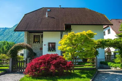 a white house with a brown roof at Apartma Rombon Brdo with Free Onsite Parking in Bovec