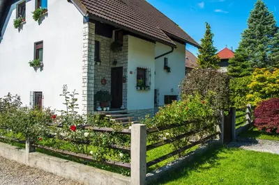a white house with a wooden fence at Apartma Rombon Brdo with Free Onsite Parking in Bovec