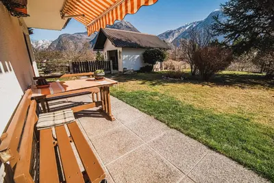 a picnic table on a patio with mountains in the background at Apartma Rombon Brdo with Free Onsite Parking in Bovec
