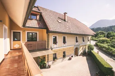 a house with a balcony with a view of a street at Mama Mia Apartments in Radovljica