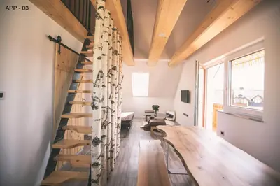 a wooden staircase in a room with a table at Mama Mia Apartments in Radovljica