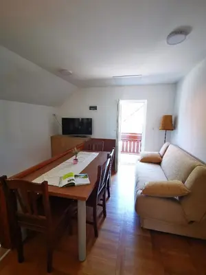 a living room with a table and a couch at Apartmaji Tomšič in Mojstrana