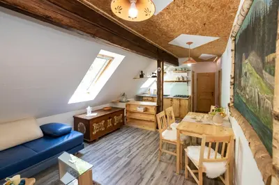 a living room with a table and a blue couch at Apartma waterfall Slap in Bohinj
