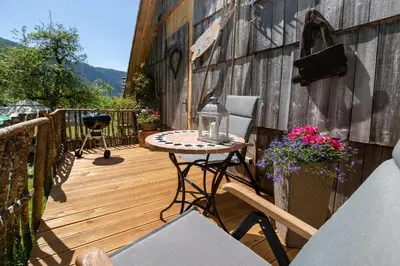 a wooden deck with a table and chairs on it at Apartma waterfall Slap in Bohinj