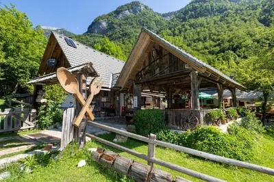 a wooden cabin with a fence and a large wooden spoon at Apartma waterfall Slap in Bohinj
