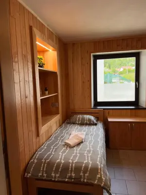 a small room with a bed in a boat at APARTMA BENY with SAUNA in Žaga