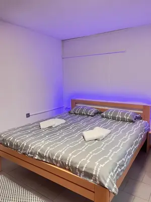 a bedroom with a bed with two pillows on it at APARTMA BENY with SAUNA in Žaga