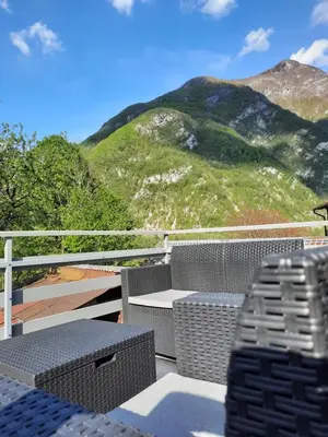 a balcony with a table and chairs and a mountain at APARTMA BENY with SAUNA in Žaga