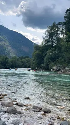 a river with rocks and people in boats on it at APARTMA BENY with SAUNA in Žaga