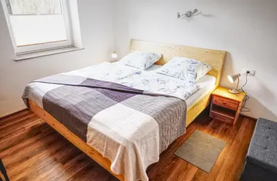 a bedroom with a bed with a blanket and a window at Apartma in studio Jerca ob Savi in Bohinj
