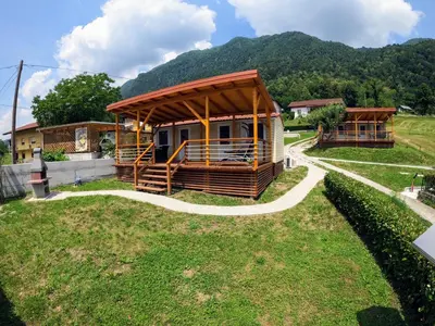 a building with a gazebo in the grass at Holiday HOUSE NEAR THE SOČA RIVER in Tolmin