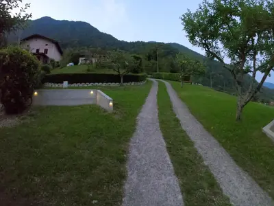 a path in the grass with a house in the background at Holiday HOUSE NEAR THE SOČA RIVER in Tolmin
