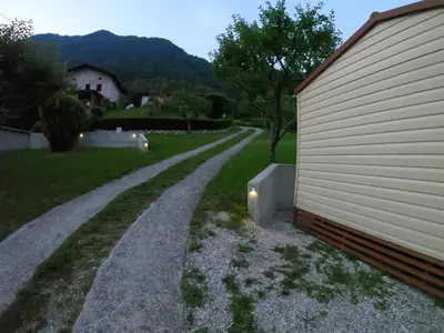 a gravel road next to a house and a building at Holiday HOUSE NEAR THE SOČA RIVER in Tolmin
