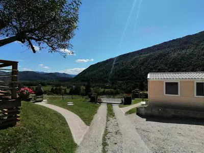 a house and a road next to a mountain at Holiday HOUSE NEAR THE SOČA RIVER in Tolmin