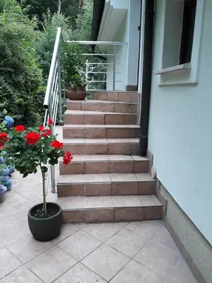 a set of stairs with red flowers in a pot at Apartma Dolomiti in Ljubljana