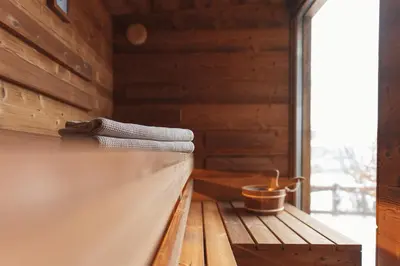 a sauna with a towel and a bucket on a ledge at Hotel Majerca Superior in Bohinj