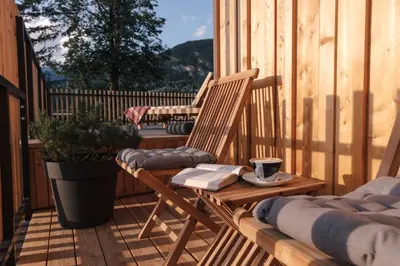 two wooden chairs and a table on a deck at Hotel Majerca Superior in Bohinj