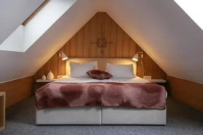 a bedroom with a large bed in a attic at Hotel Majerca Superior in Bohinj