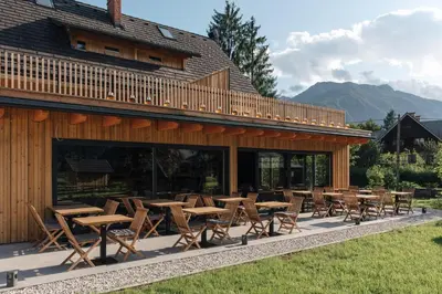 a group of tables and chairs in front of a building at Hotel Majerca Superior in Bohinj
