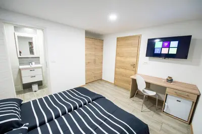 a bedroom with a bed and a desk and a television at Guesthouse Urša in Preddvor