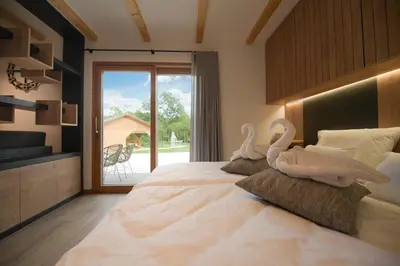 two swans sitting on a bed in a bedroom at Chalet Zana in Bled