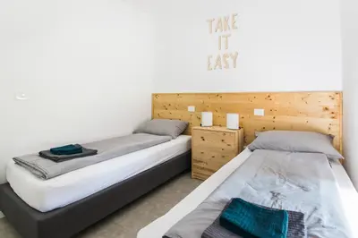two beds sitting next to each other in a bedroom at Positive sport apartments in Kobarid