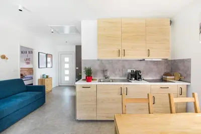 a kitchen with wooden cabinets and a blue couch at Positive sport apartments in Kobarid