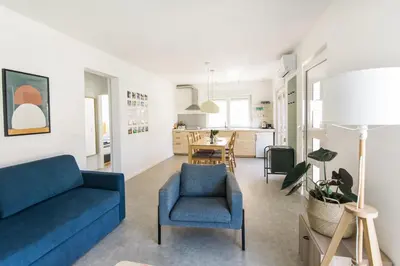 a living room with a blue couch and a dining room at Positive sport apartments in Kobarid