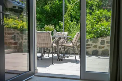 an open door to a patio with a table and chairs at Apartments Korošec in Bled
